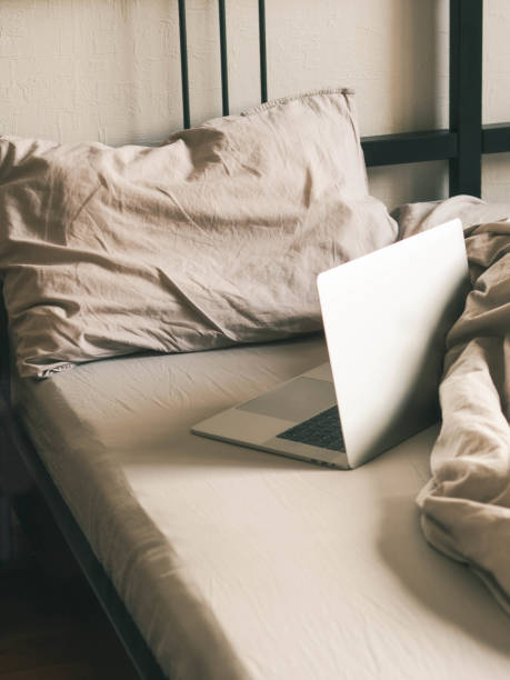istock Laptop on the bed in the bedroom. Work from home or comfortable pastime online. 1220168052