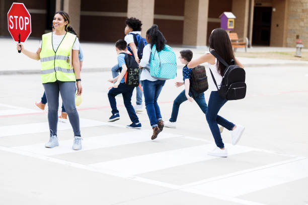 istock Schoolchildren run across crosswalk 1220169272