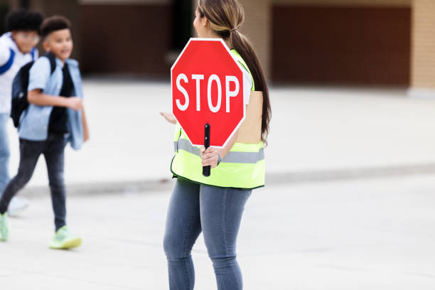 istock Crossing guard holds stop sign 1220169277