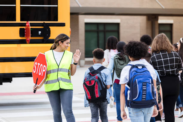 istock School crossing guard directs students across the street 1220169285