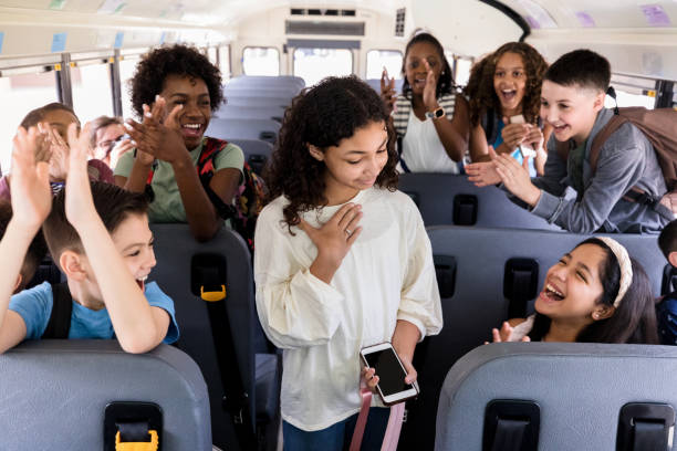 istock Children clap and laugh while waiting on school bus 1220169369