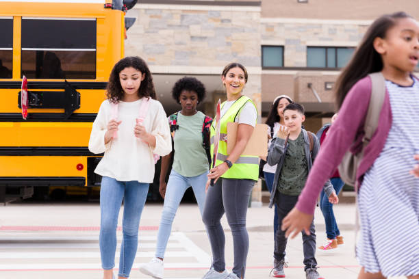 istock Crossing guard with stop sign has cheerful smile for students 1220169430