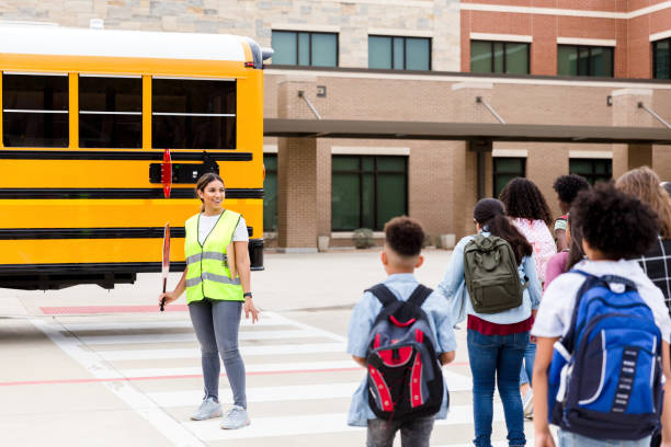istock Crossing guard greets children as they head toward school 1220169436