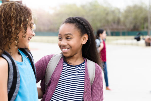 istock Two elementary age girls hug after school 1220169448