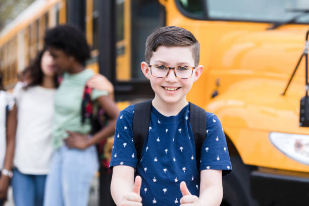 istock Before boarding on bus, elementary age boy gives thumbs up 1220169473