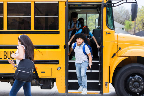 istock Excited schoolchildren unload school bus 1220169590