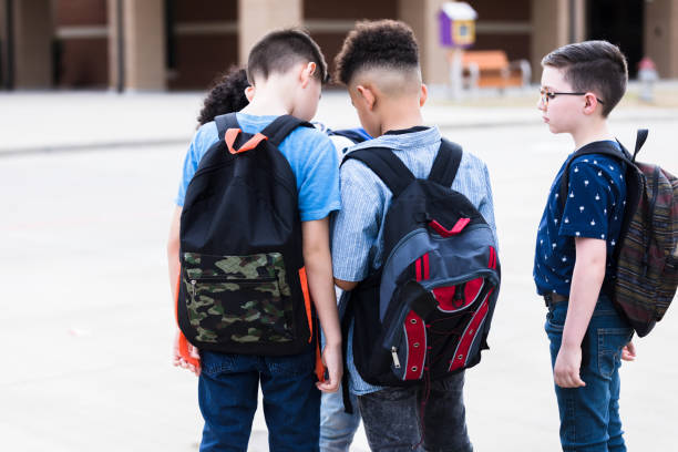 istock Schoolboys gather together to look at smartphone 1220169605