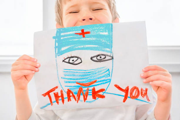 Thank you hospital workers. Coronavirus doctors thank you. Child sends message of gratitude thanks to doctors and nurses. Symbol of hope during Covid-19 outbreak. Healthcare workers gracias ayudantes del coronavirus. los trabajadores clave son trabajadores del hospital. símbolo de esperanza durante el brote de coronavirus covid-19. los trabajadores sanitarios son trabajadores clave durante la pandemia. gracias al personal médico