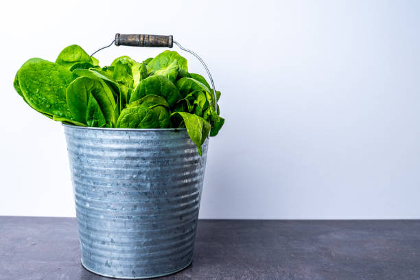 istock Metal bucket full with fresh spinach leaves 1220172004