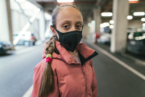 Young girl wearing protective face mask for health and anti-virus protection under coronavirus quarantine isolation