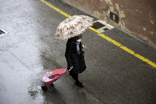 Person with umbrella on street raining, nature and walking