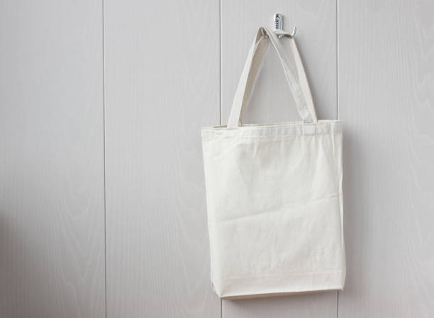 istock white linen bag hanging on a hook on a light wall. 1220176951