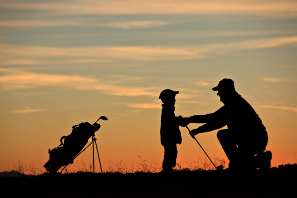 istock Silhouette of Young Junior Golfer Getting A Lesson From His Dad 1220177518