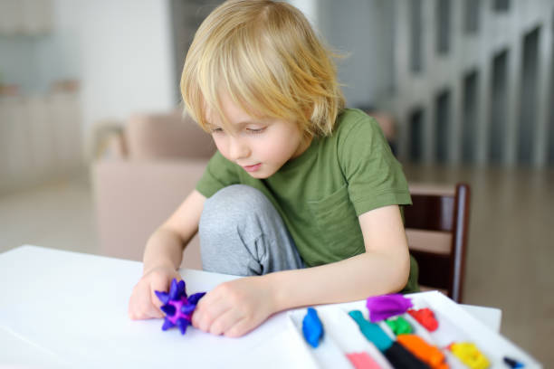 istock Little boy playing dough at home during coronavirus quarantine. Child is molding from plasticine model virus covid-19. Creativities lessons, homeschooling. Kids entertainments while stay home. 1220178008