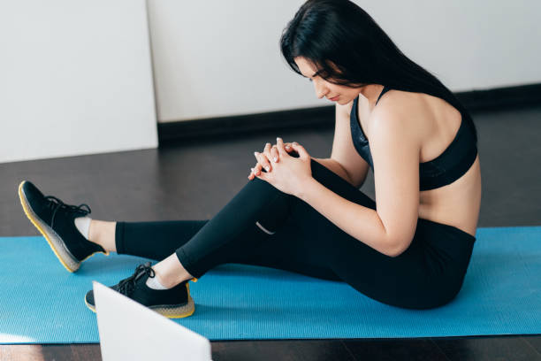 istock Woman suffering from knee ache at home training 1220178675