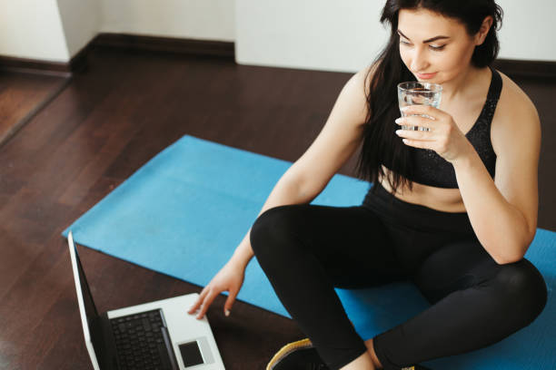 istock Woman drinking water looking online video guide 1220178682