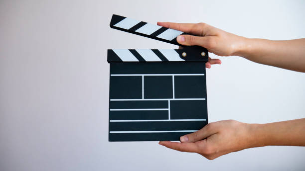 istock In hand wooden black clapperboard isolated on gray background. 1220178774