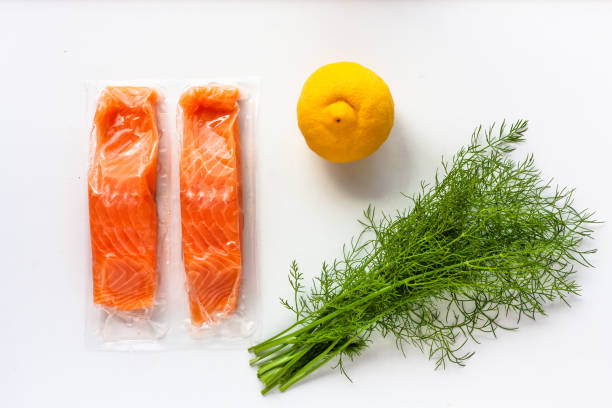 istock Red fish o salmon fillets in vacuum package on white background. lemon and dill. Fresh fish, lemon and dill for cooking ingredients. Concept of healthy eating. Omega-3. Close up. Copy space. 1220180277