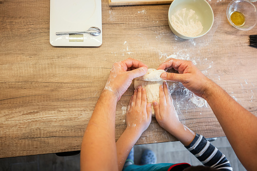 Cute boy learning to bake with his father