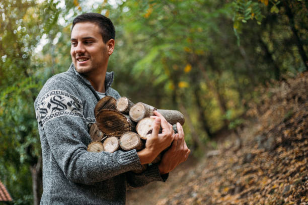 istock Handsome young man carrying a pile of wood 1220180421