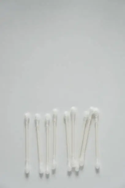 Q tip, or cotton bud swab top view on vertical white background with blank empty space for copy or text; Features best health care hygiene practices to clean ear.