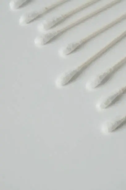 Q tip, or cotton bud swab top view on vertical white background with blank empty space for copy or text; Features best health care hygiene practices to clean ear.
