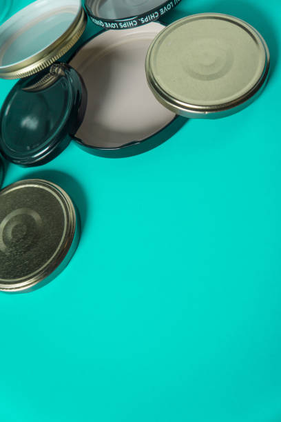 istock Recycling glass jar lids for reuse of single use items; Zero no waste recycle program campaigns; Recyclable concept on blank empty copyspace, text room space for copy on vertical cyan background. 1220181441