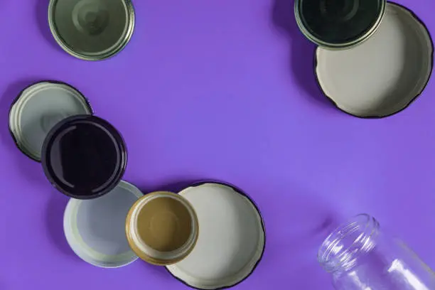 Recycling glass jar lids for reuse of single use items; Zero no waste recycle program campaigns; Recyclable concept on blank empty copyspace, text room space for copy on horizontal purple background.