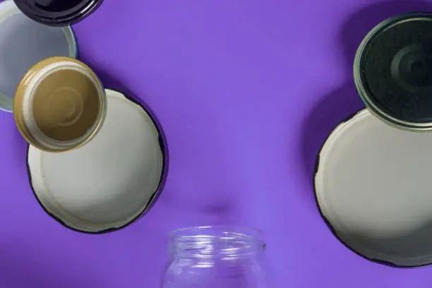 Recycling glass jar lids for reuse of single use items; Zero no waste recycle program campaigns; Recyclable concept on blank empty copyspace, text room space for copy on horizontal purple background.