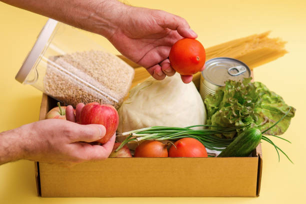 istock A man holding a box of fruit and vegetables 1220187624