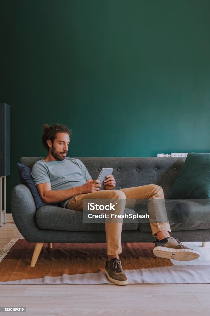 zingen gastvrouw dief Man Sitting On A Sofa And Using A Digital Tablet At Home Stock Photo -  Download Image Now - iStock