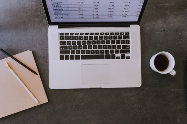 istock Businessman's Desk: Overhead View of an Open Laptop With a Report on the Screen 1220189231