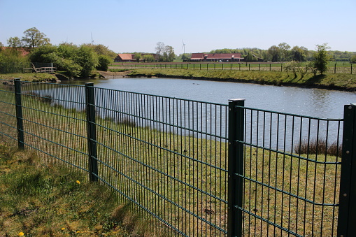 a lattice mat fence blocks access to the lake