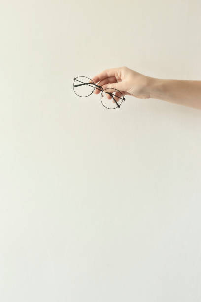 istock Glasses in a thin metal frame in the hands. 1220190683
