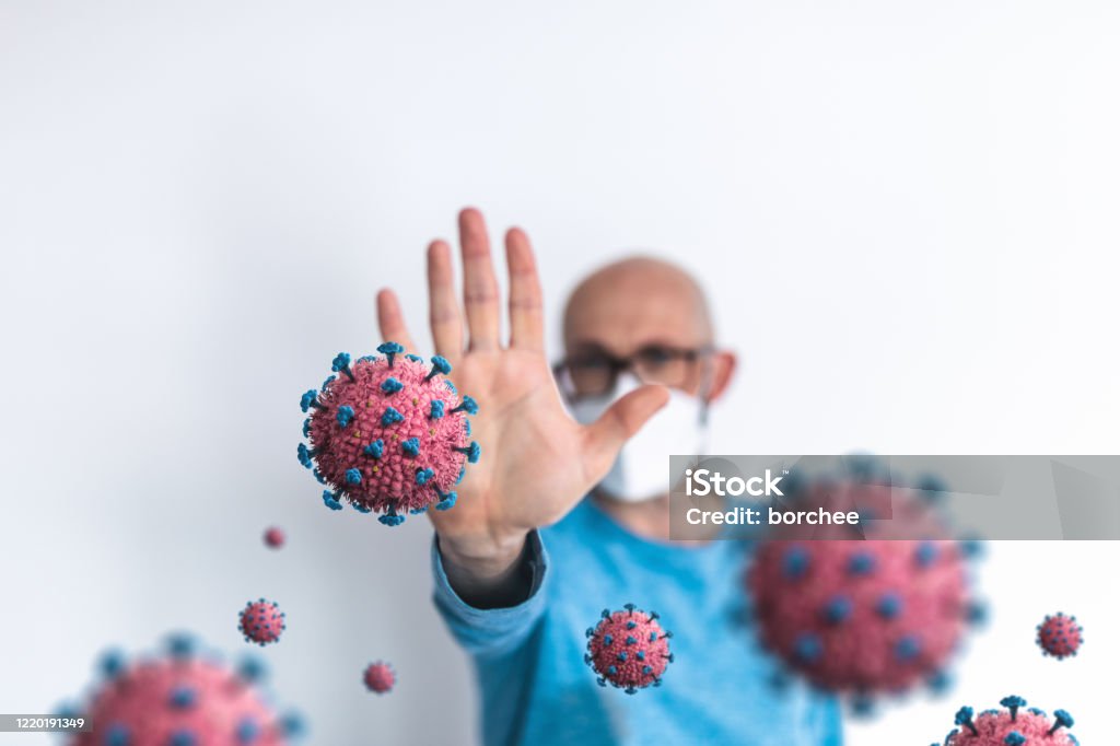 Stop The Coronavirus Message Man with protective face mask gesturing stop sign with the hand. Concept of viral infection - Coronavirus epidemic. Stop Sign Stock Photo