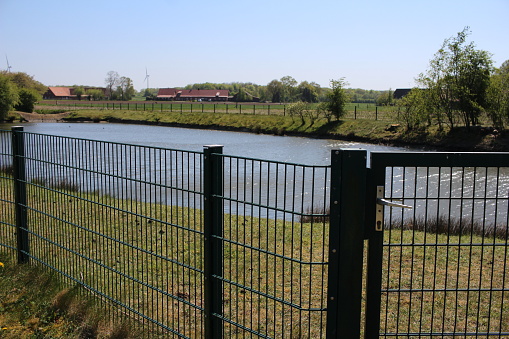 a lattice mat fence blocks access to the lake