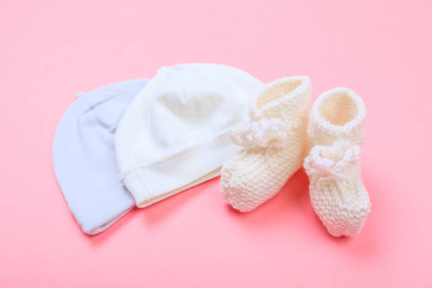 istock knitted baby booties and bonnet on pastel pink background - Image 1220192625