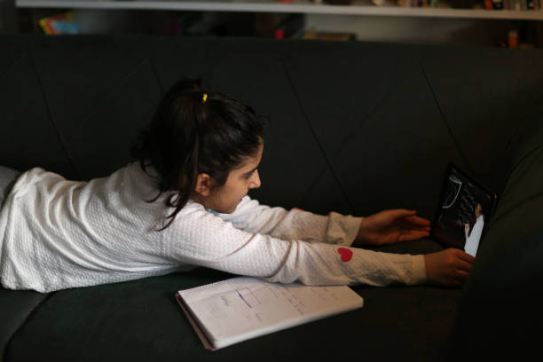 istock Little girl is studying online from digital tablet 1220193409