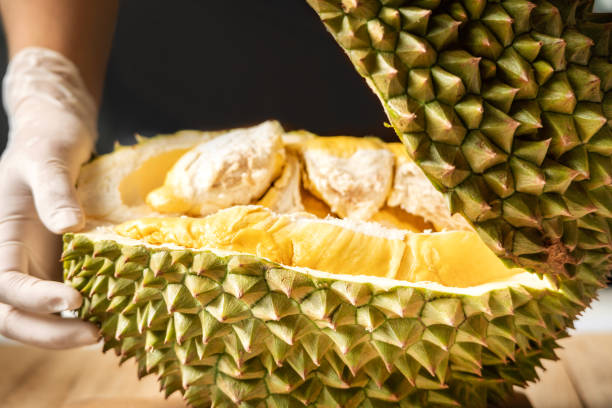 istock close up hand peeling durian with bright yellow flesh inside 1220194232