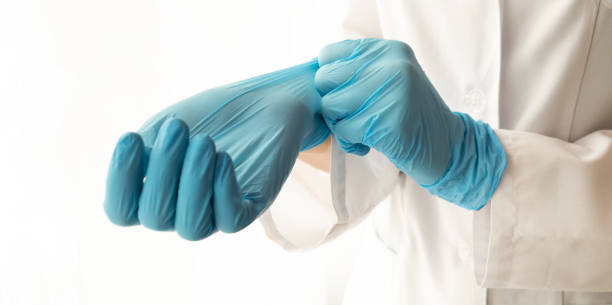 istock Doctor putting on protective gloves, isolated on white 1220194737