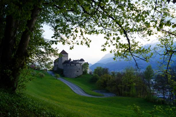 Landscape of Vaduz Castle with road and  Switzerland Alps background. It is an official residence of the Prince of Liechtenstein.