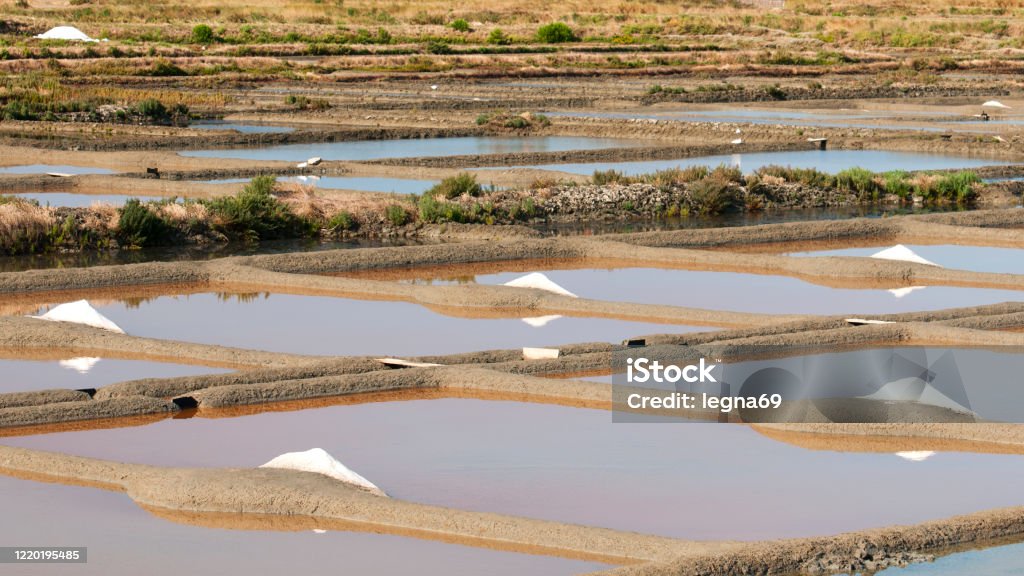 Panoramic view on piles of salt in marsh, in Guerande - Fran Famous place for handmade production, the salt marshes are located between Guerande, Le Croisic and Batz sur Mer. They provide the typical landscape of this country. Craft Stock Photo