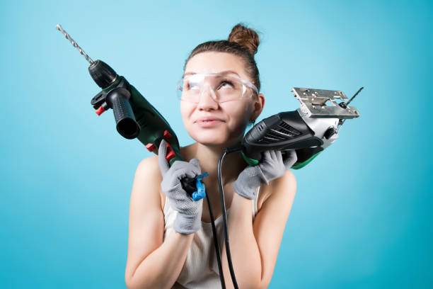 istock Pensive girl and a jigsaw with an electric drill on a background 1220195596