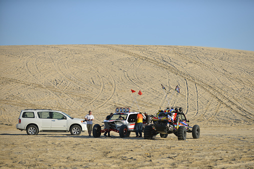 Beach Buggies racing in the afternoon sun in the sand dunes of the Qatari desert, Doha, Qatar