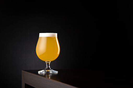 Glass of cold lemon beer on a bar counter with copy space