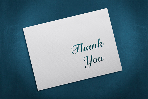Envelope with Thank You Message and white ornament on dark background.
