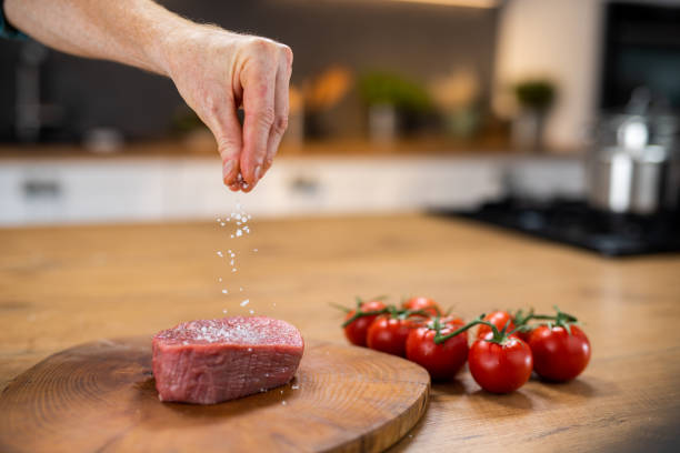 肉に塩を加えるシェフ - 塩をふる ストックフォトと画像