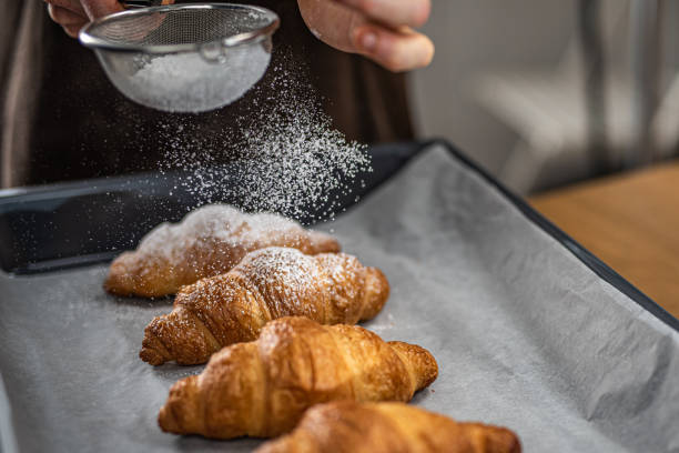 istock Chef sprinkling powdered sugar on croissants 1220200270