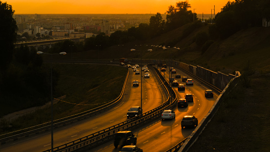 City traffic on the road. Sunset light, golden hour. Transportation concept