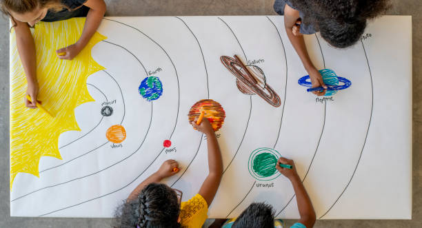 istock Kids colouring a picture of outer space 1220202209